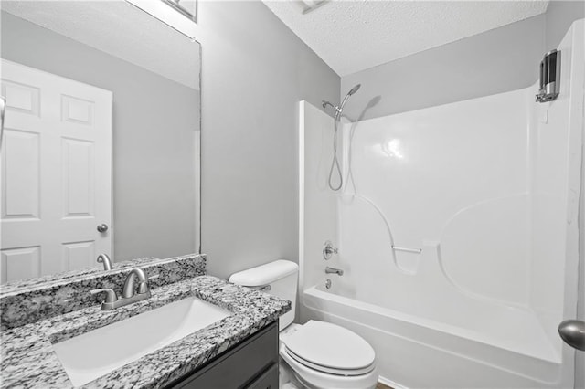 full bathroom with vanity, bathing tub / shower combination, toilet, and a textured ceiling