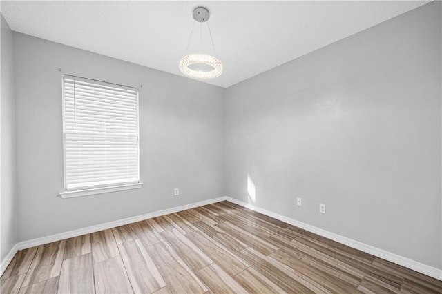 spare room with wood finished floors and baseboards