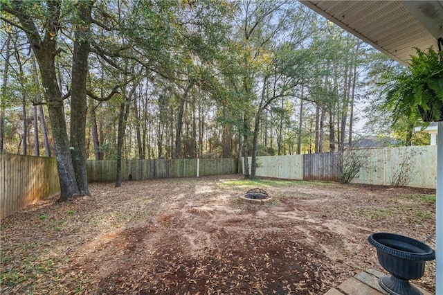 view of yard featuring a fire pit and a fenced backyard