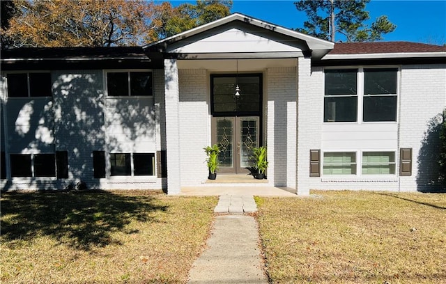 view of front facade featuring brick siding and a front yard