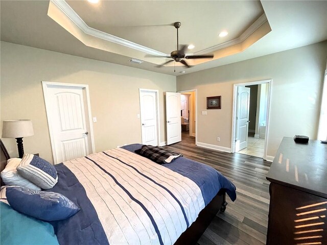 bedroom with crown molding, ceiling fan, a raised ceiling, and dark hardwood / wood-style flooring