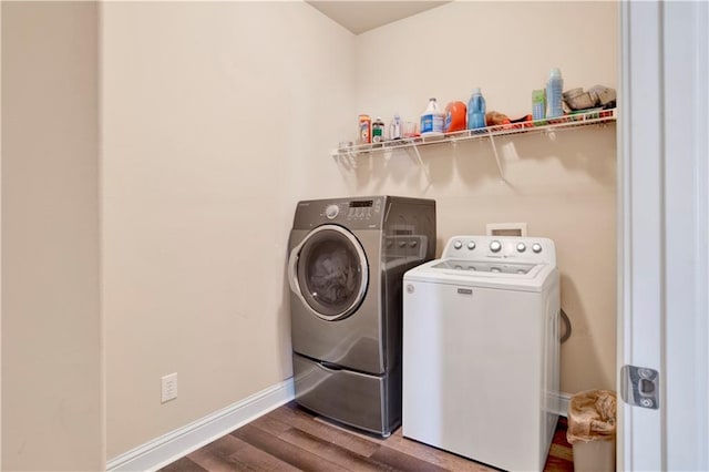 laundry room with separate washer and dryer and hardwood / wood-style flooring