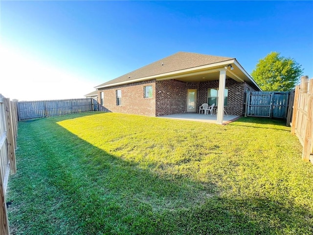 rear view of house with a patio and a lawn