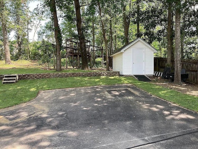 exterior space featuring an outbuilding, fence, and a shed