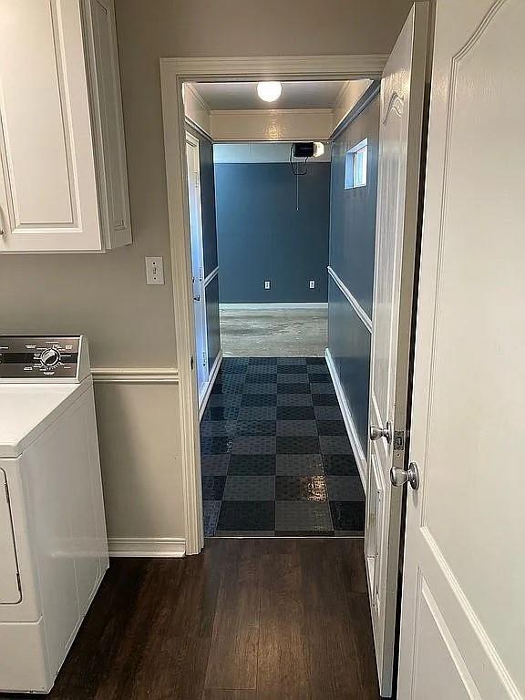 clothes washing area with wood finished floors, baseboards, washer / clothes dryer, and cabinet space