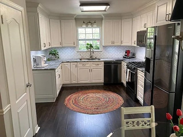 kitchen featuring black appliances, a sink, backsplash, dark wood finished floors, and white cabinets