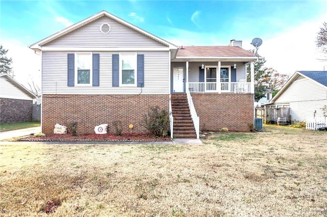 view of front of house with covered porch, a front yard, and central AC