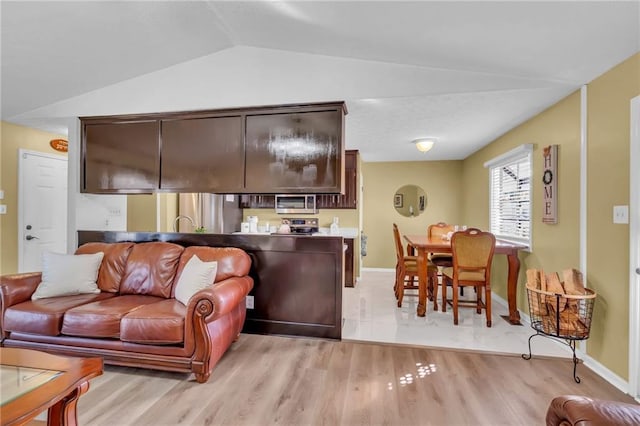 living room featuring vaulted ceiling and light hardwood / wood-style flooring