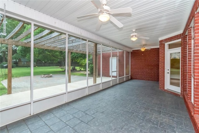 unfurnished sunroom featuring ceiling fan