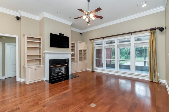 empty room featuring dark wood-type flooring, ceiling fan, and crown molding