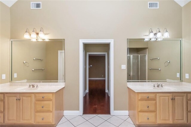 bathroom with tile patterned flooring, vanity, vaulted ceiling, and plus walk in shower