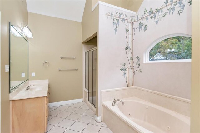 bathroom with tile patterned flooring, vaulted ceiling, a washtub, and vanity