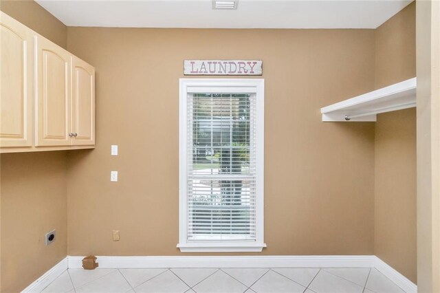 laundry room with light tile patterned floors, cabinets, and electric dryer hookup