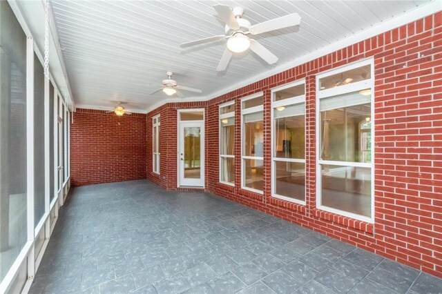 unfurnished sunroom with ceiling fan