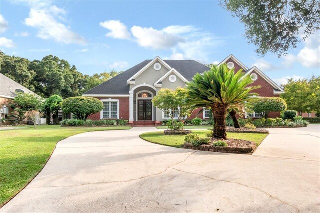 view of front of property with french doors and a front lawn