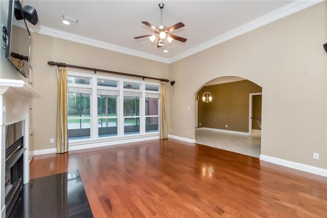 unfurnished living room featuring ceiling fan, ornamental molding, and hardwood / wood-style flooring