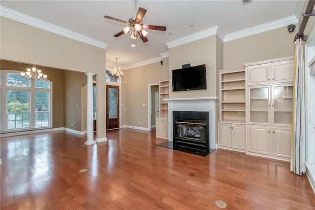 unfurnished living room featuring crown molding, ceiling fan with notable chandelier, hardwood / wood-style flooring, and ornate columns