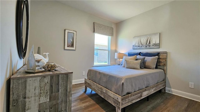 bedroom with wood finished floors, baseboards, and freestanding refrigerator