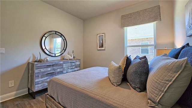 bedroom with dark wood-style floors and baseboards