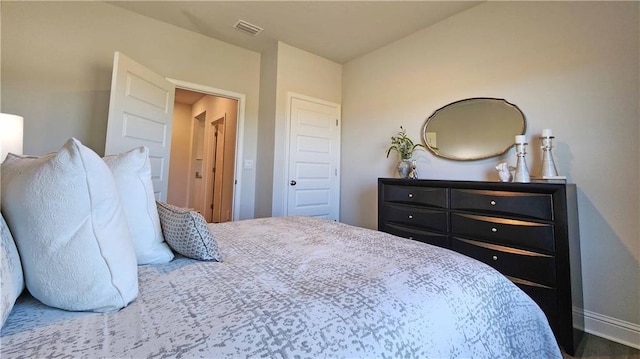 bedroom with baseboards and visible vents