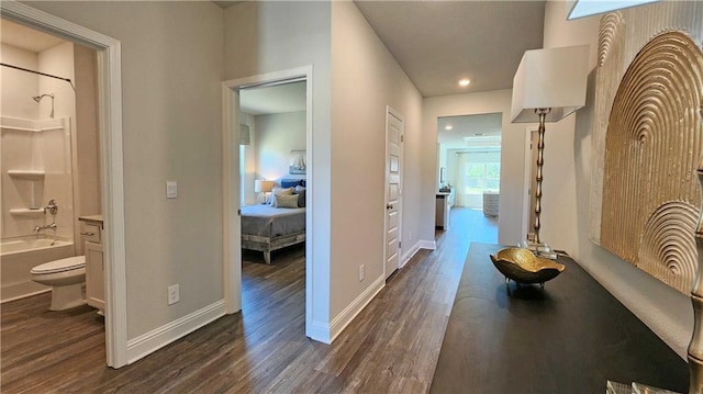 hall with dark wood-type flooring and baseboards