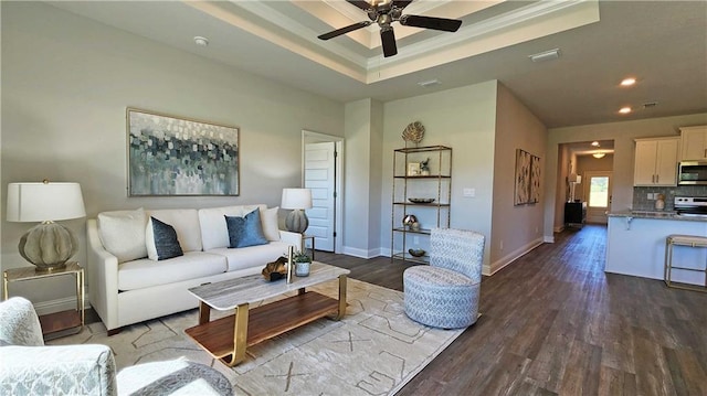 living room featuring visible vents, baseboards, a tray ceiling, dark wood-style flooring, and ceiling fan