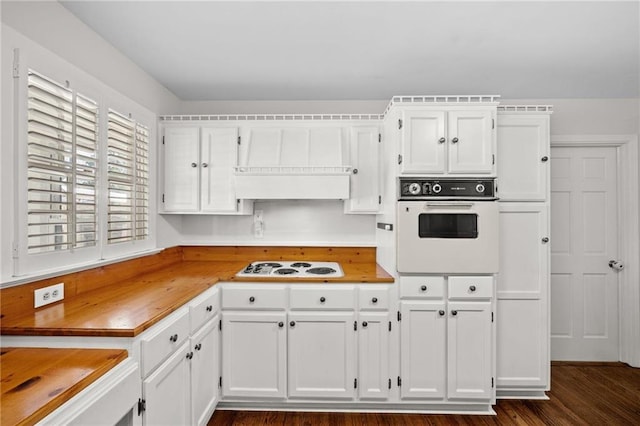 kitchen featuring butcher block countertops, white cabinetry, dark wood-style flooring, and white appliances