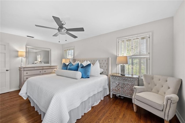 bedroom featuring a ceiling fan, wood finished floors, multiple windows, and visible vents