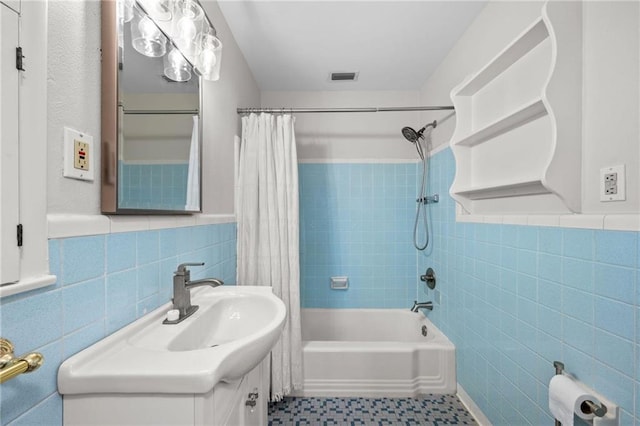 bathroom featuring shower / bath combo, visible vents, tile walls, and vanity