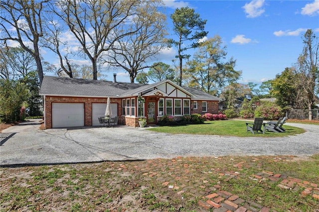 view of front of property with brick siding, driveway, an attached garage, and a front lawn
