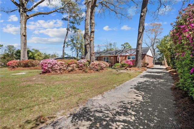 single story home with a front yard, brick siding, and driveway
