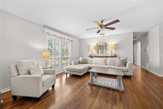 living area with baseboards, wood finished floors, and ceiling fan