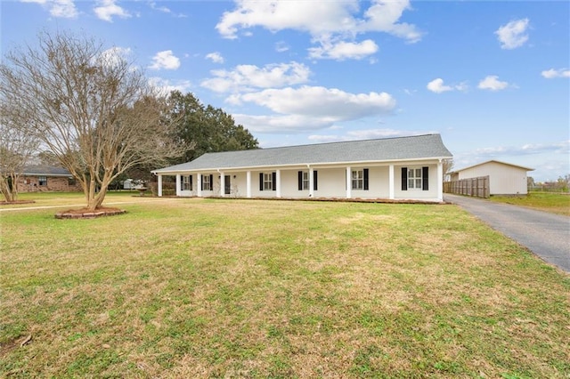 ranch-style home featuring a front lawn and covered porch