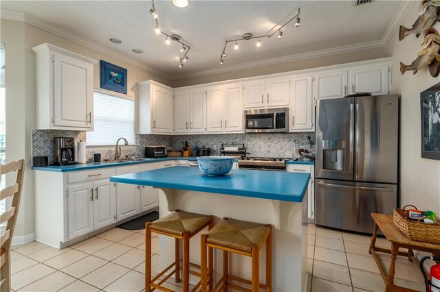 kitchen featuring crown molding, white cabinetry, sink, and stainless steel appliances