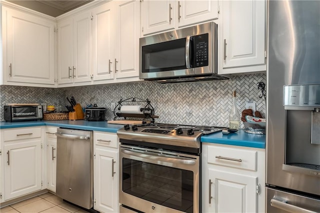 kitchen featuring tasteful backsplash, crown molding, white cabinets, and stainless steel appliances