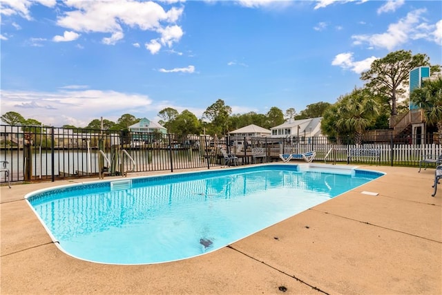 view of swimming pool featuring a water view and a patio