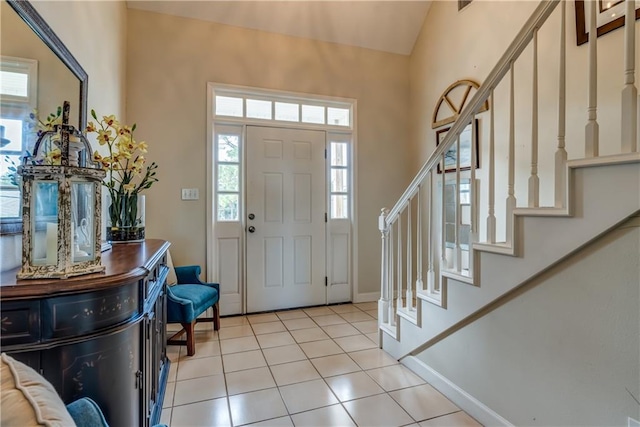 tiled entryway featuring a healthy amount of sunlight and lofted ceiling