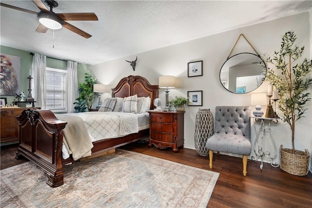 bedroom with a textured ceiling, ceiling fan, and dark wood-type flooring