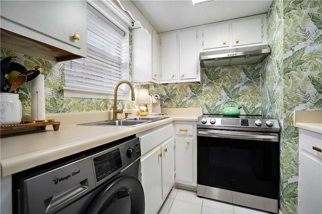 kitchen with sink, stainless steel range oven, washer / clothes dryer, white cabinetry, and light tile patterned flooring