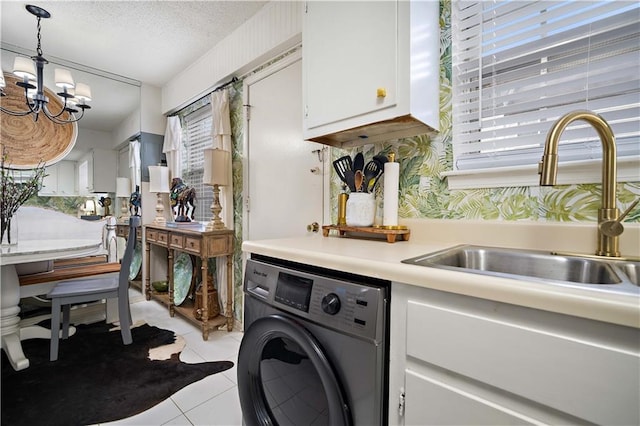 laundry room with sink, washer / clothes dryer, a chandelier, a textured ceiling, and light tile patterned floors