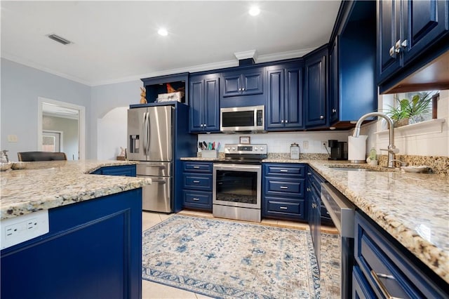 kitchen with blue cabinetry, stainless steel appliances, crown molding, and a sink