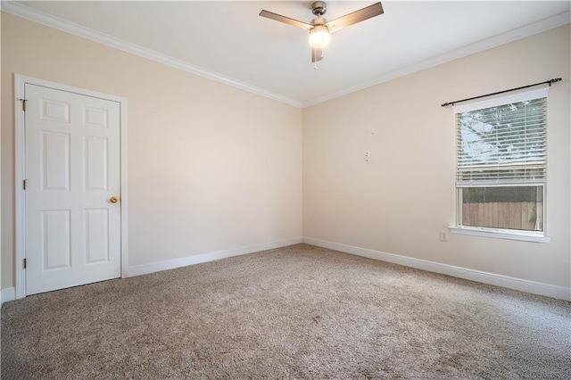 carpeted spare room with ceiling fan, baseboards, and ornamental molding