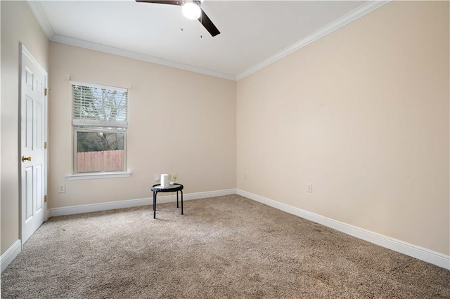 carpeted spare room with ceiling fan, baseboards, and ornamental molding