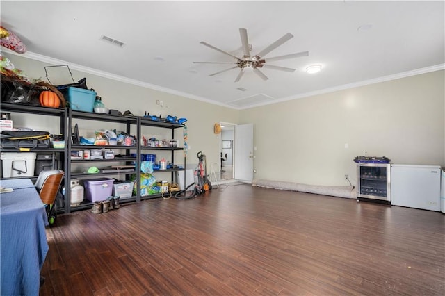 interior space with visible vents, wood finished floors, beverage cooler, and crown molding