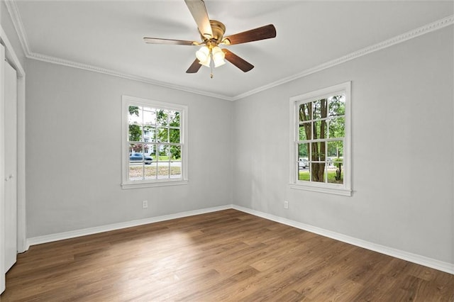 empty room with ceiling fan, baseboards, ornamental molding, and wood finished floors