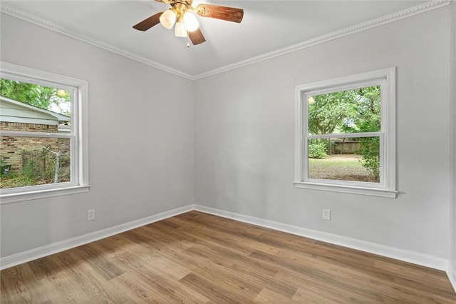 spare room featuring ceiling fan, baseboards, ornamental molding, and wood finished floors