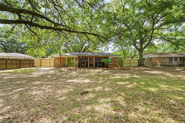 view of yard featuring a sunroom and a fenced backyard