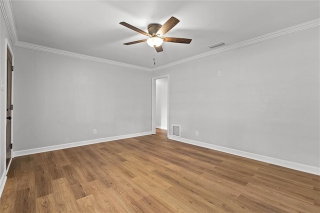 empty room featuring baseboards, ceiling fan, visible vents, and wood finished floors