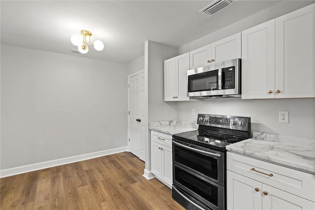 kitchen with visible vents, white cabinetry, appliances with stainless steel finishes, and wood finished floors
