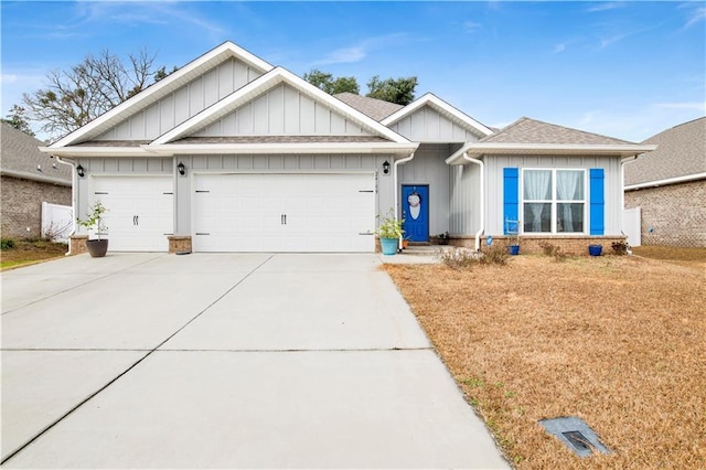 view of front of property featuring an attached garage, driveway, a shingled roof, and board and batten siding